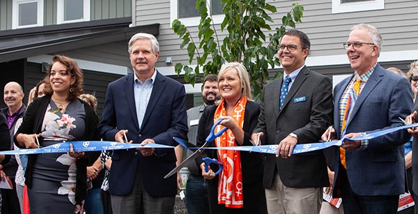 people smiling cutting ribbon